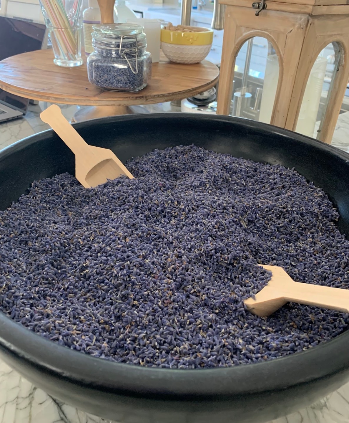 A bowl of lavender buds with wooden scoops