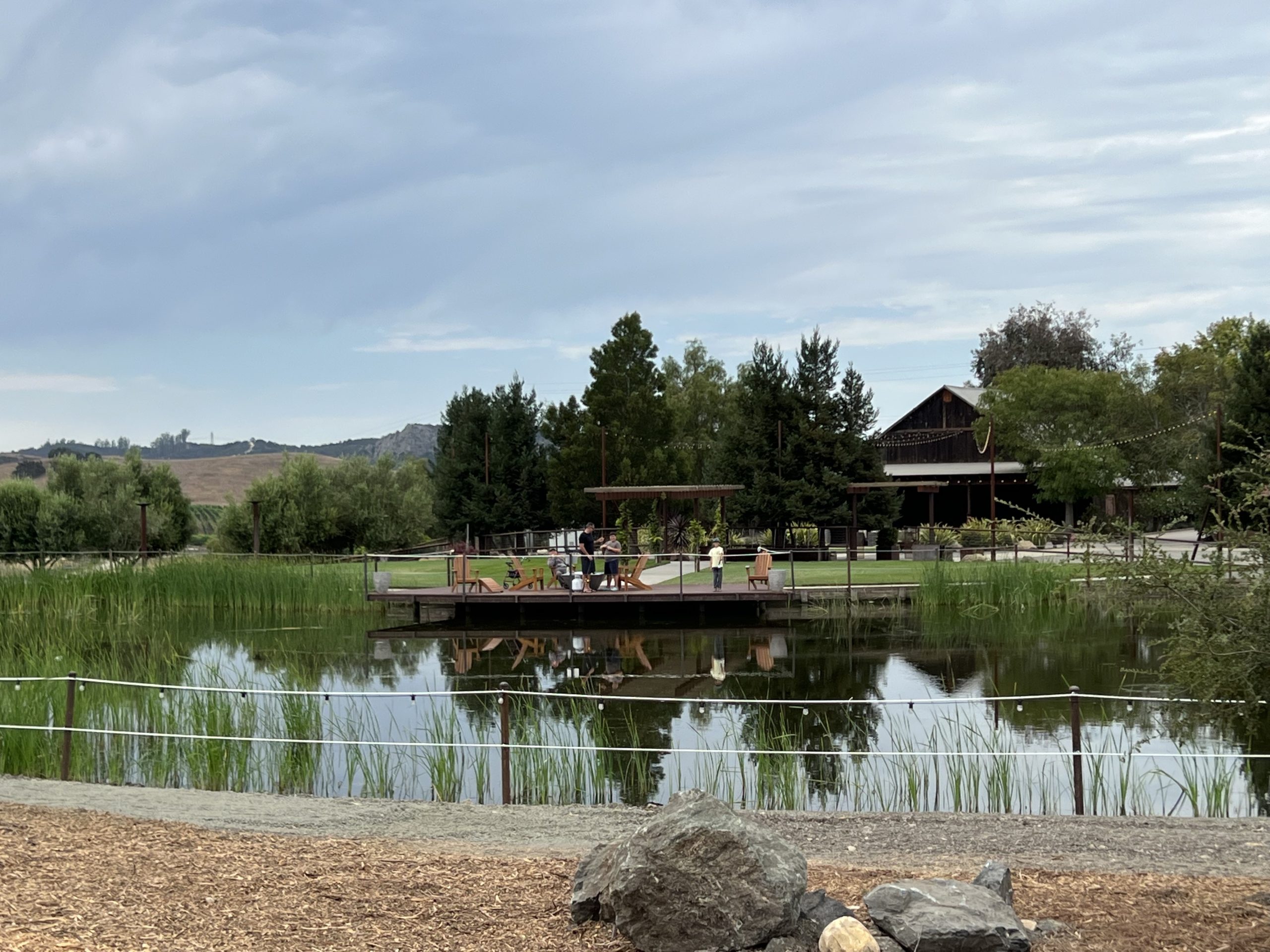People on a deck beside the estate pond